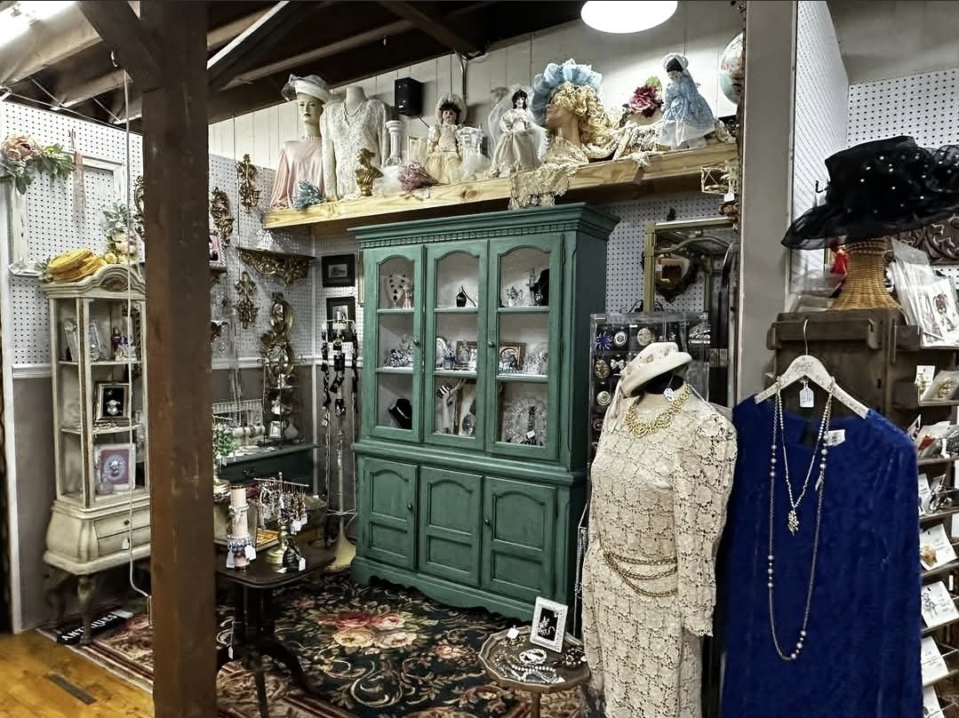 Vintage green cabinet with antique clothing and collectibles