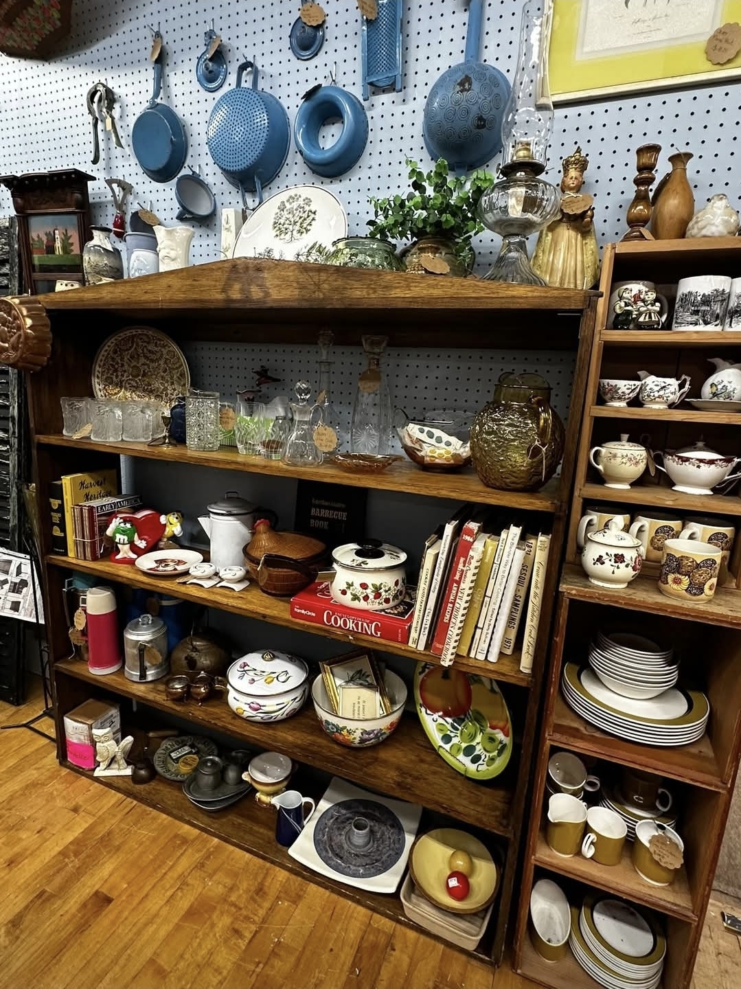 Vintage kitchen cabinet with cookware, books, and collectibles