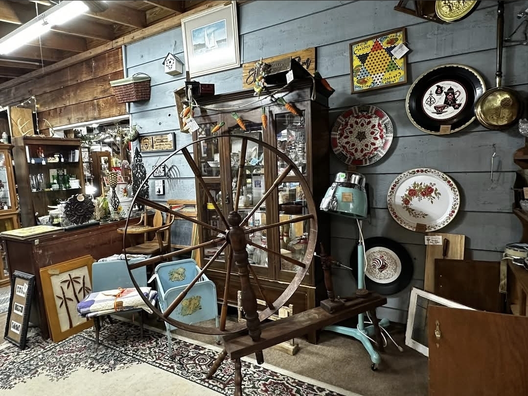 Vintage spinning wheel with decorative wall plates and art