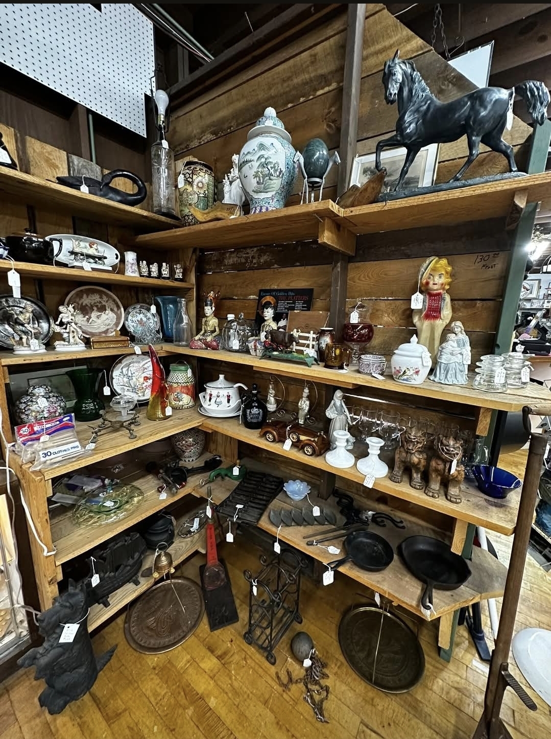 Wooden shelves filled with figurines, ceramics, and unique finds